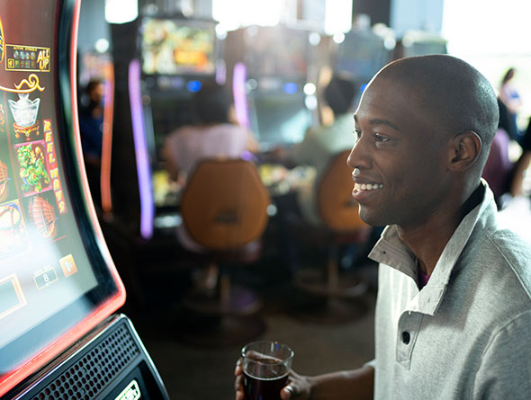 Man in gray shirt playing slots