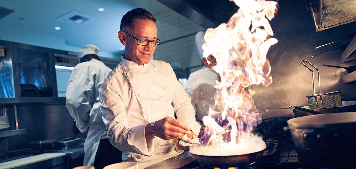 boyd property Chef with pan and flames cooking