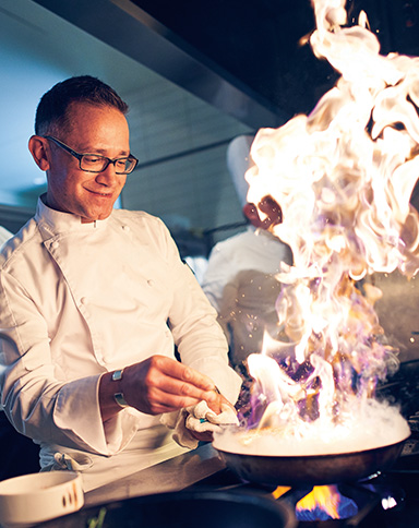 boyd property Chef with pan and flames cooking
